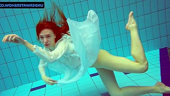 Рыжая девица плавает под водой с голой пиздой