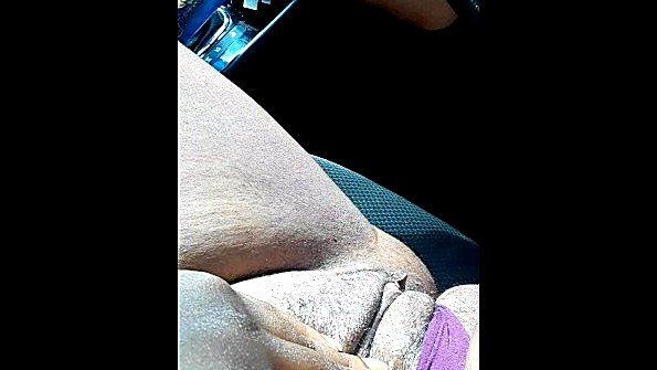 Негритянка ласкает пизду сидя за рулем машины